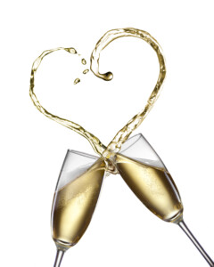 כוסות שמפניה מתנגשות, והשמפניה מותזת ועשה צורה של לב.